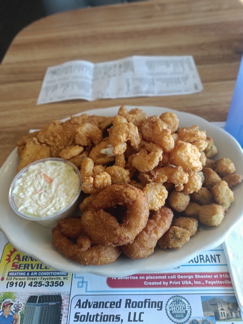 Golden hush puppies beside slaw and fried seafood.